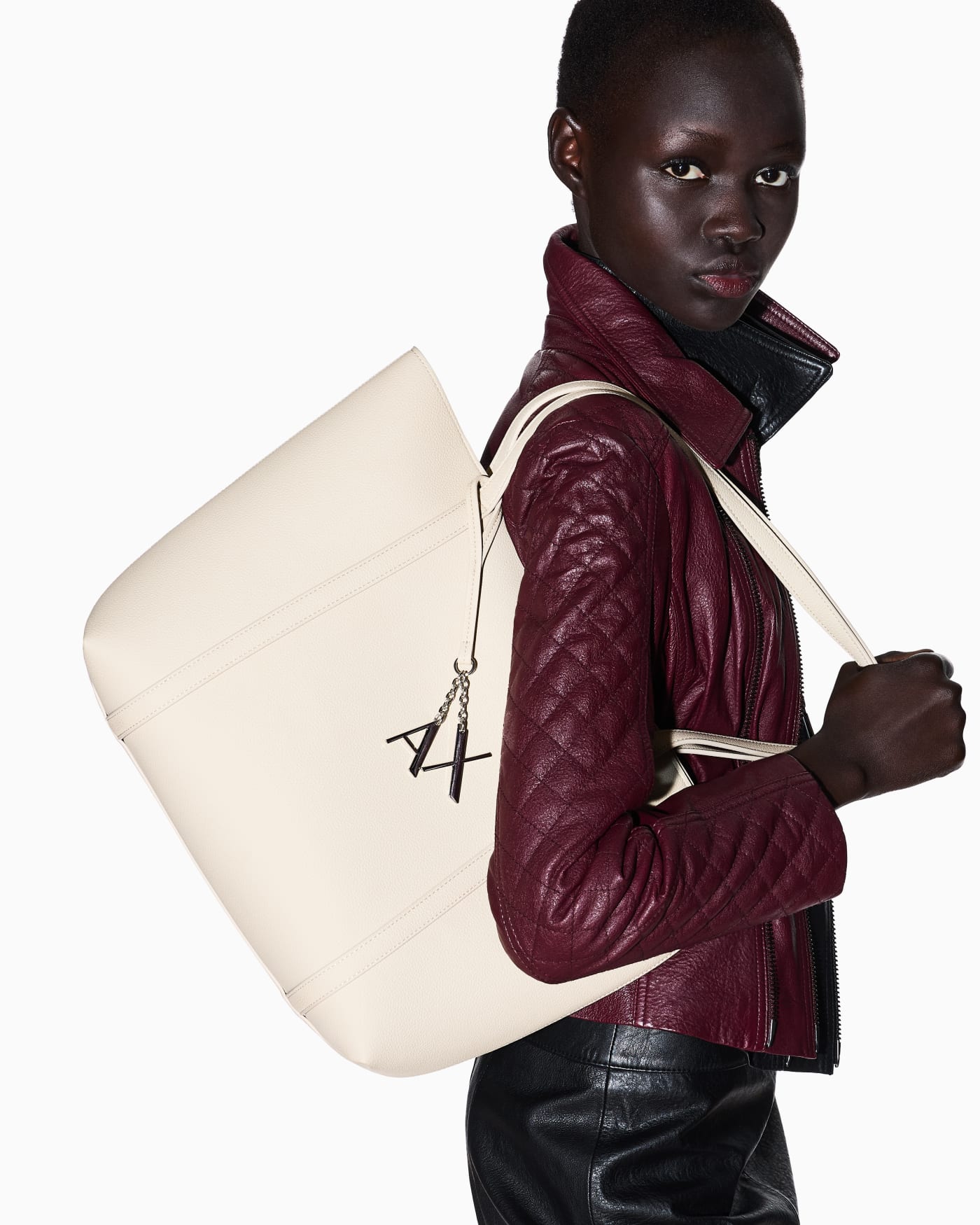 Textured tote bag with handles and a decorative charm