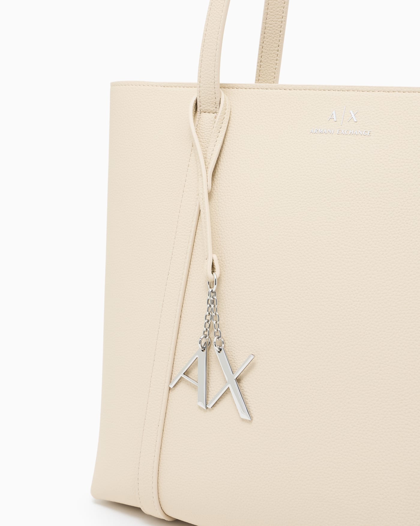 Textured tote bag with handles and a decorative charm