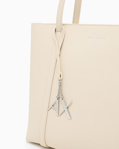 Textured tote bag with handles and a decorative charm