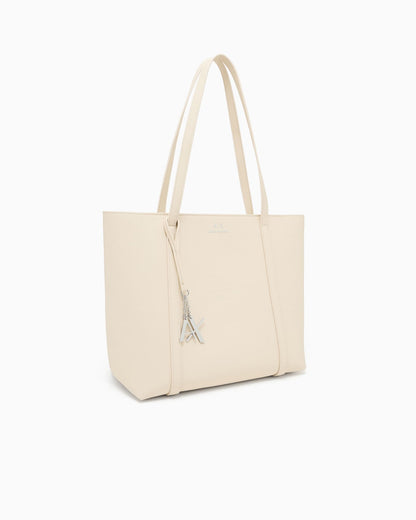 Textured tote bag with handles and a decorative charm