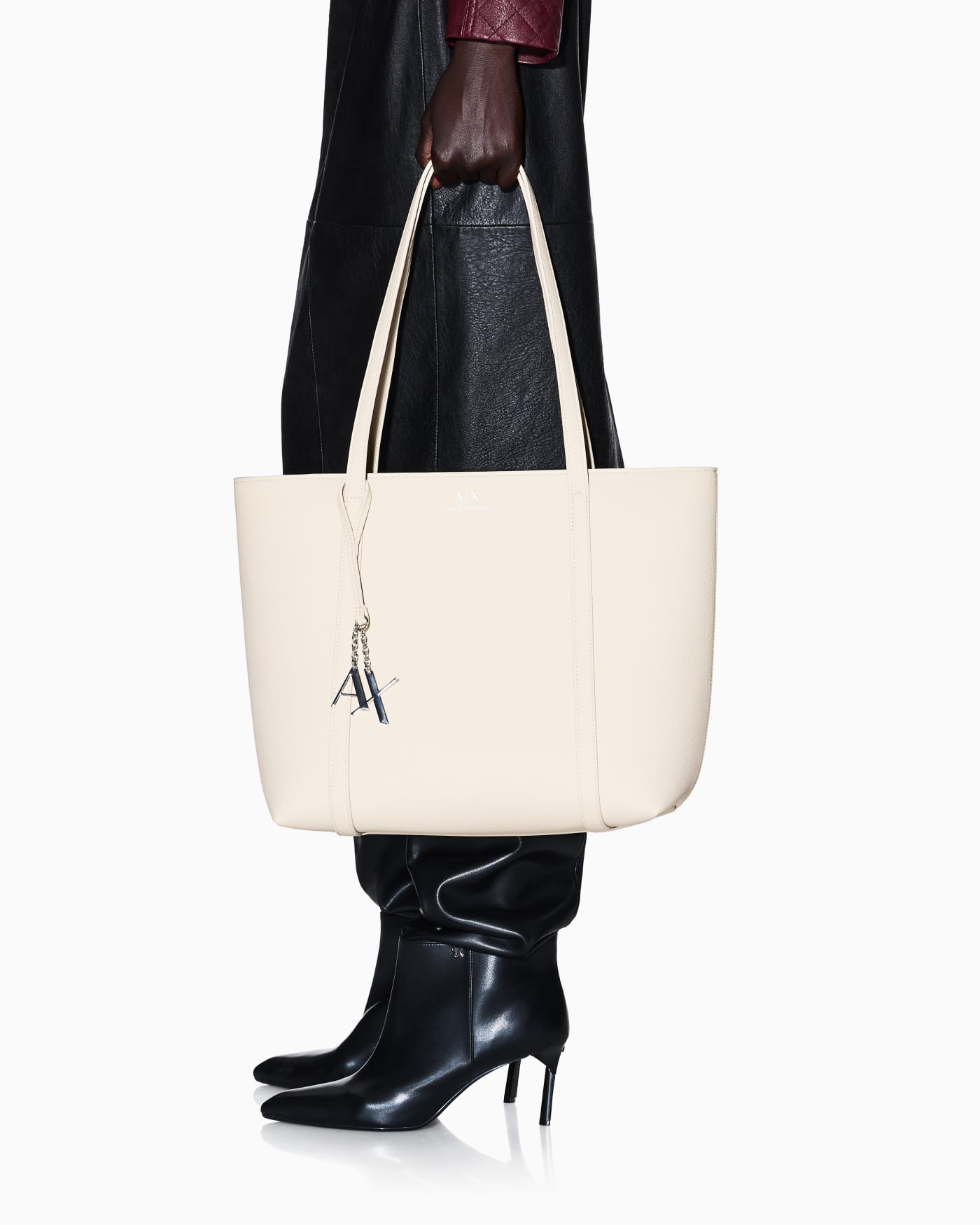 Textured tote bag with handles and a decorative charm