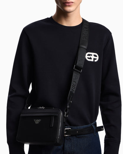 Textured crossbody bag with a front pocket and a metal logo