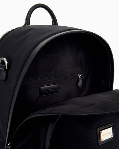 Backpack with a front zip pocket and a metal logo plaque