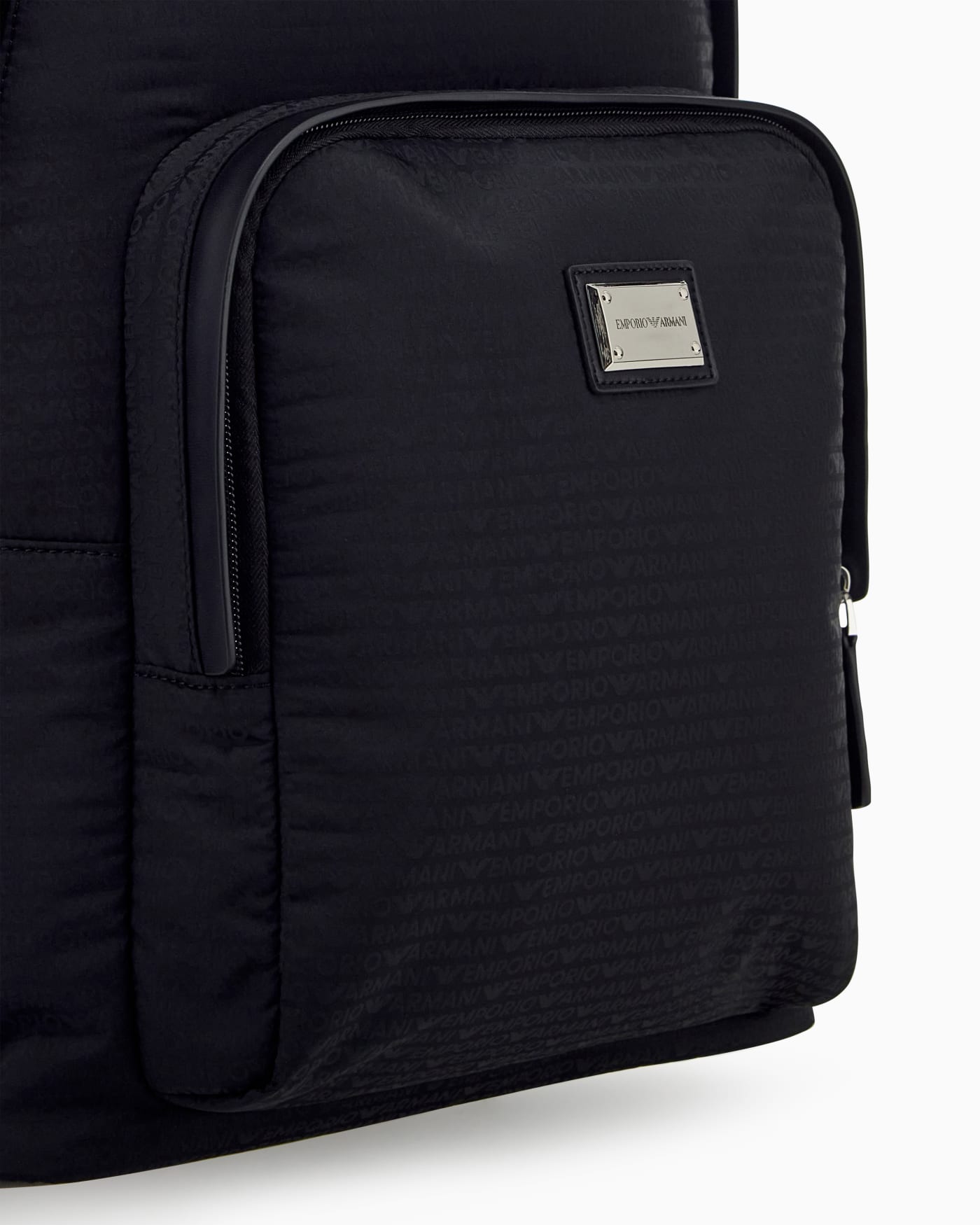 Backpack with a front zip pocket and a metal logo plaque