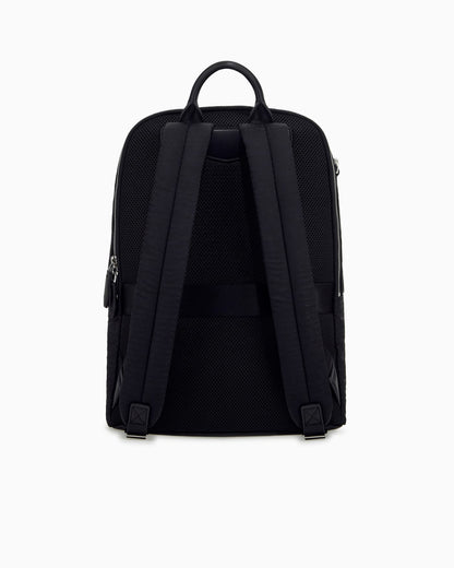 Backpack with a front zip pocket and a metal logo plaque