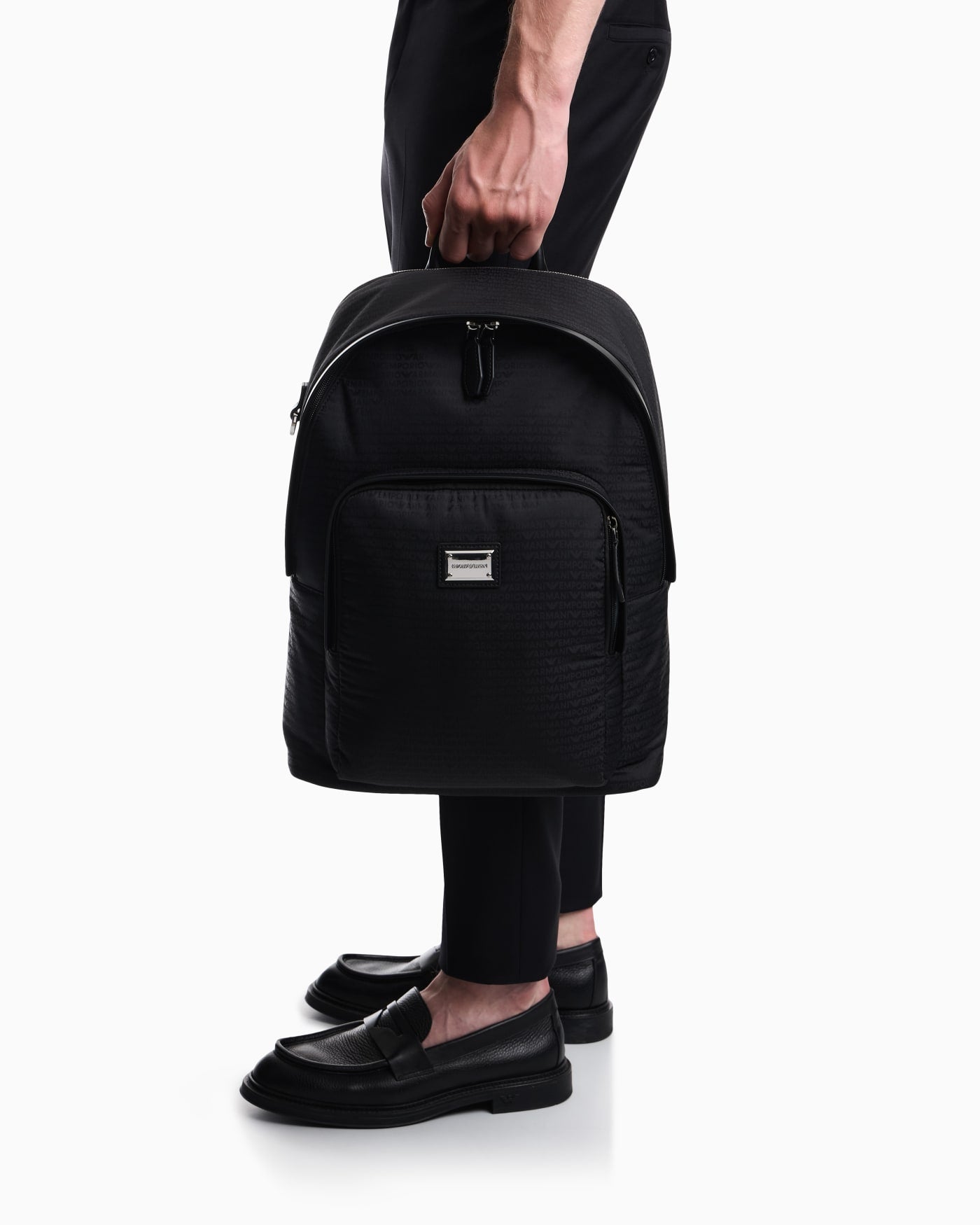 Backpack with a front zip pocket and a metal logo plaque